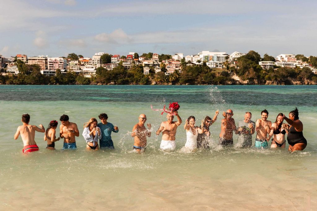 Photo de groupe originale pendant un mariage sur la plage en Guadeloupe à l'îlet Gosier