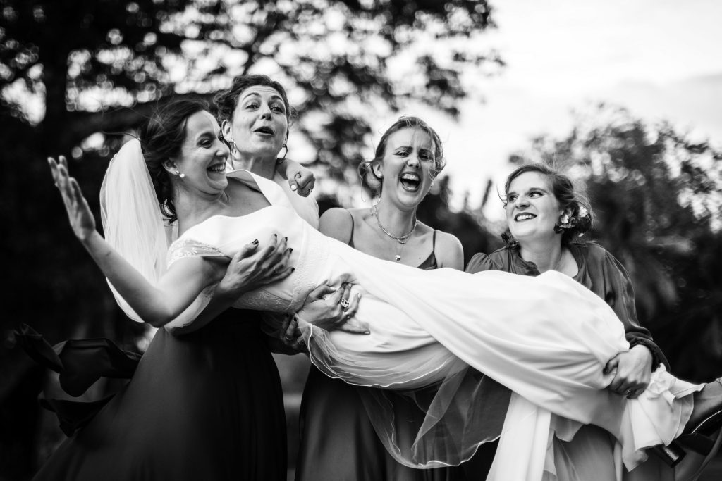 Photo de groupe originale pendant un mariage sur la plage en Guadeloupe où on porte la mariée